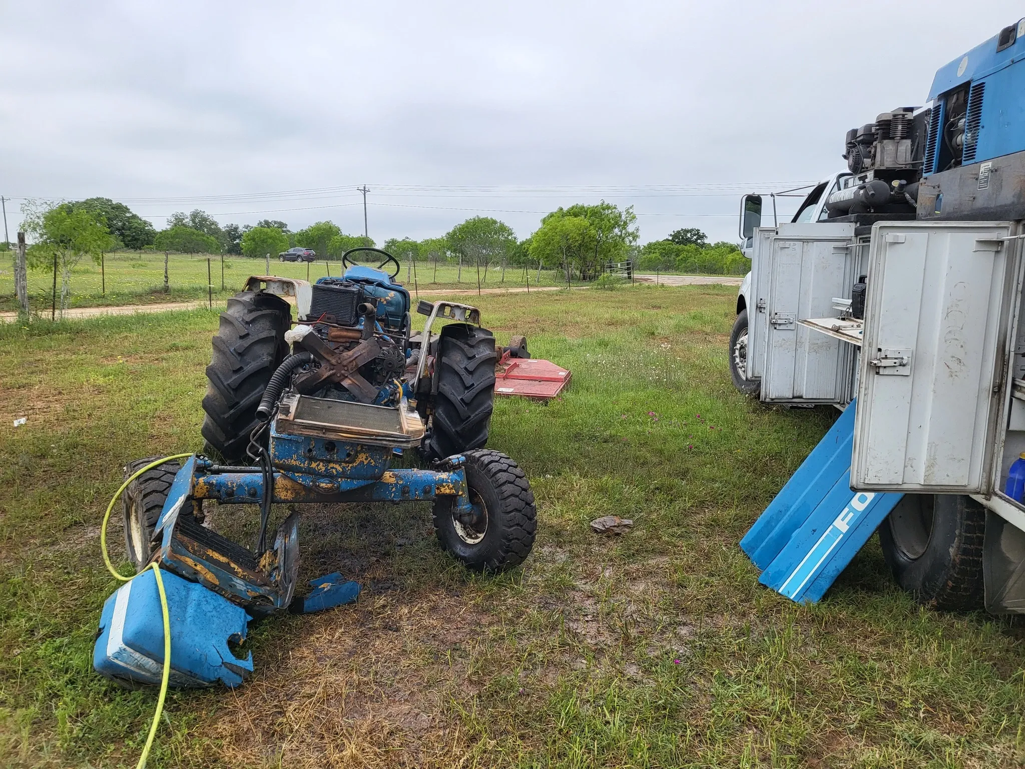 Farm tractor in a field, undergoing on-site maintenance or repair